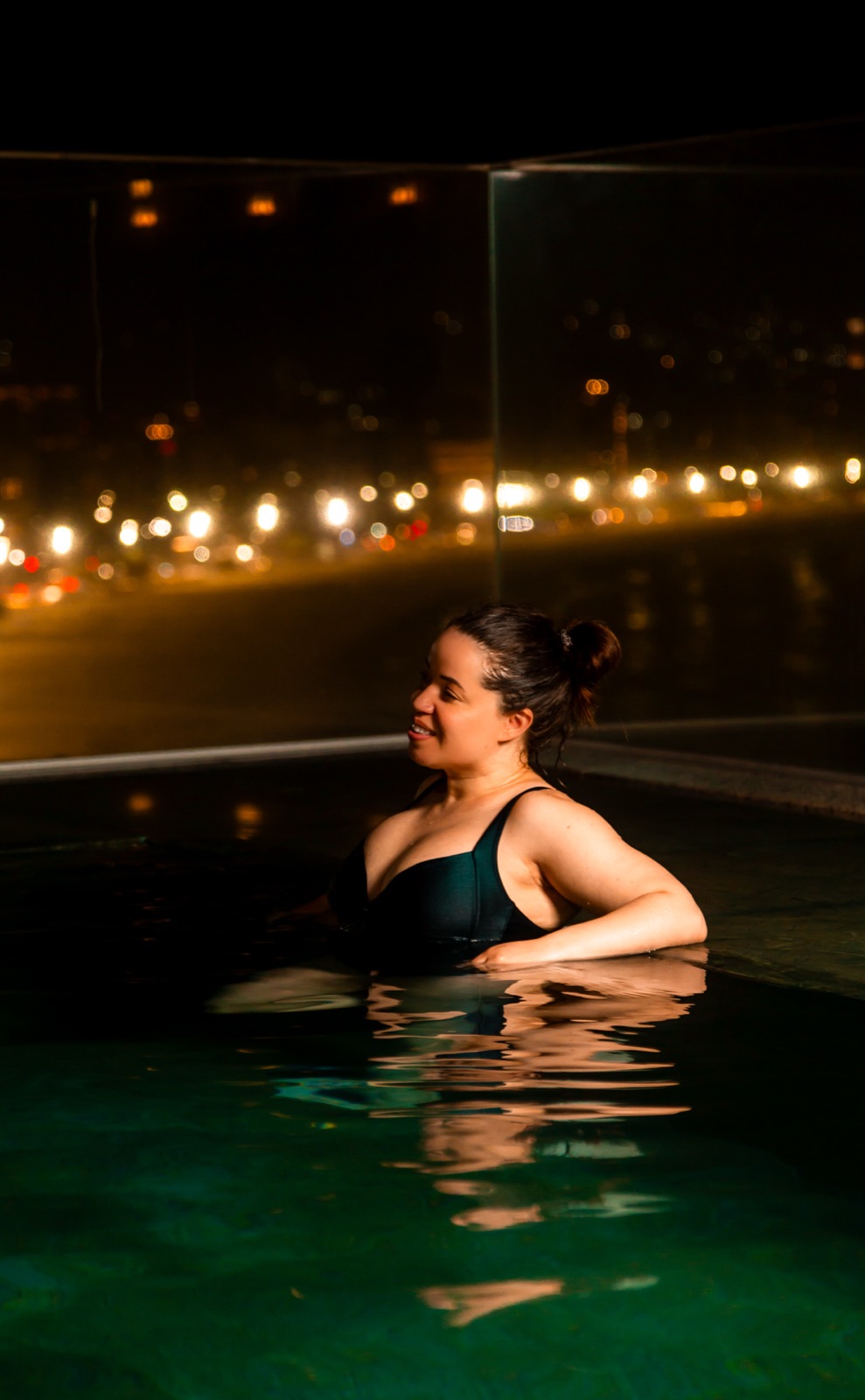 Giselle relaxing in a hotel pool at night