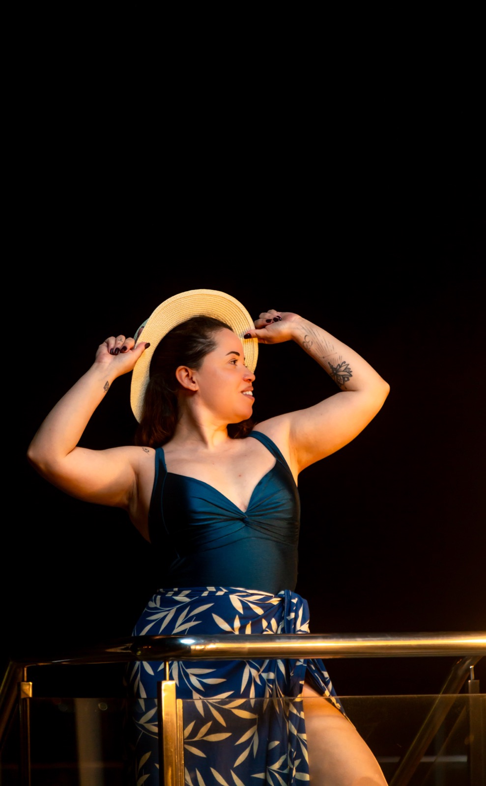 Giselle in a sunhat at a luxury hotel after dark