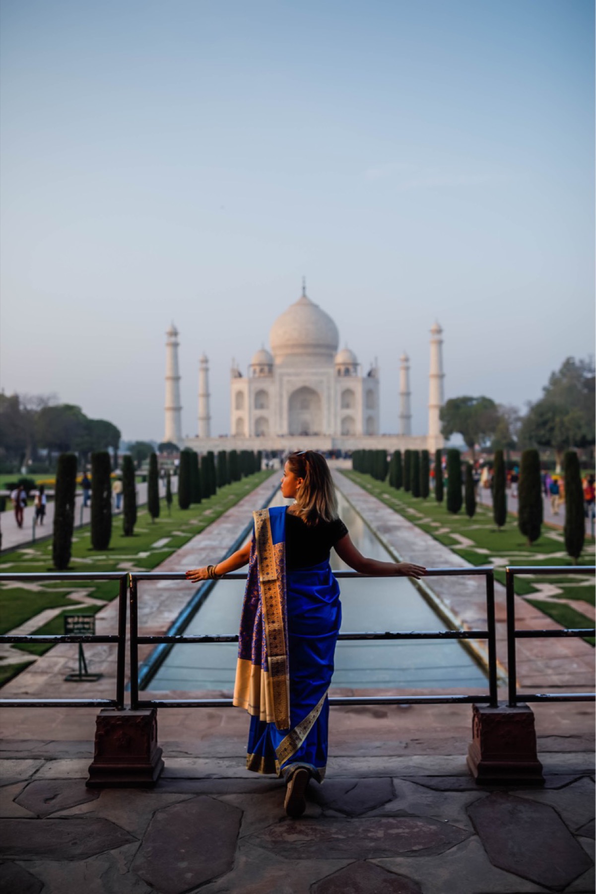 Giselle in a blue evening look on a softly lit terrace